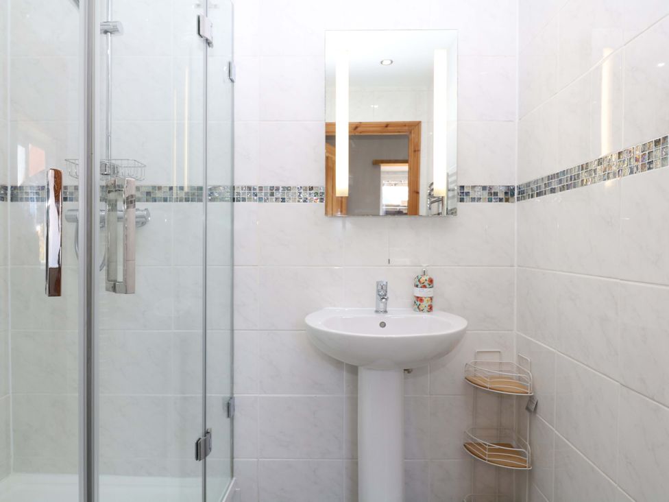 A bathroom featuring a shower, sink, and mirror at The Milk Shed in Plymtree