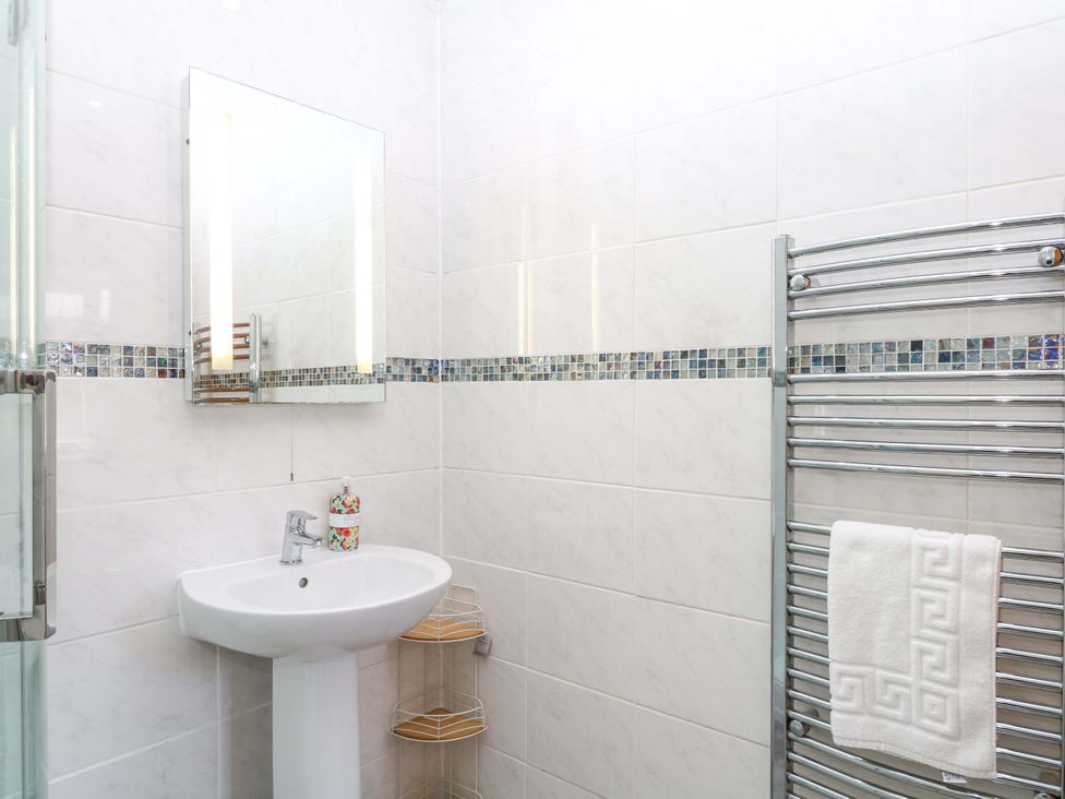 A bathroom with sink, mirror and towel rail at The Milk Shed in Plymtree