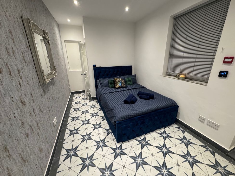 A bedroom with a bed and mirror at The Old Barn in Manchester