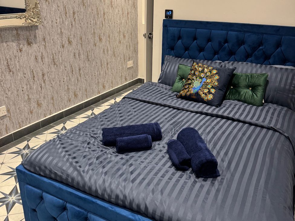 A bedroom with a blue bed and decorative pillows at a property in location