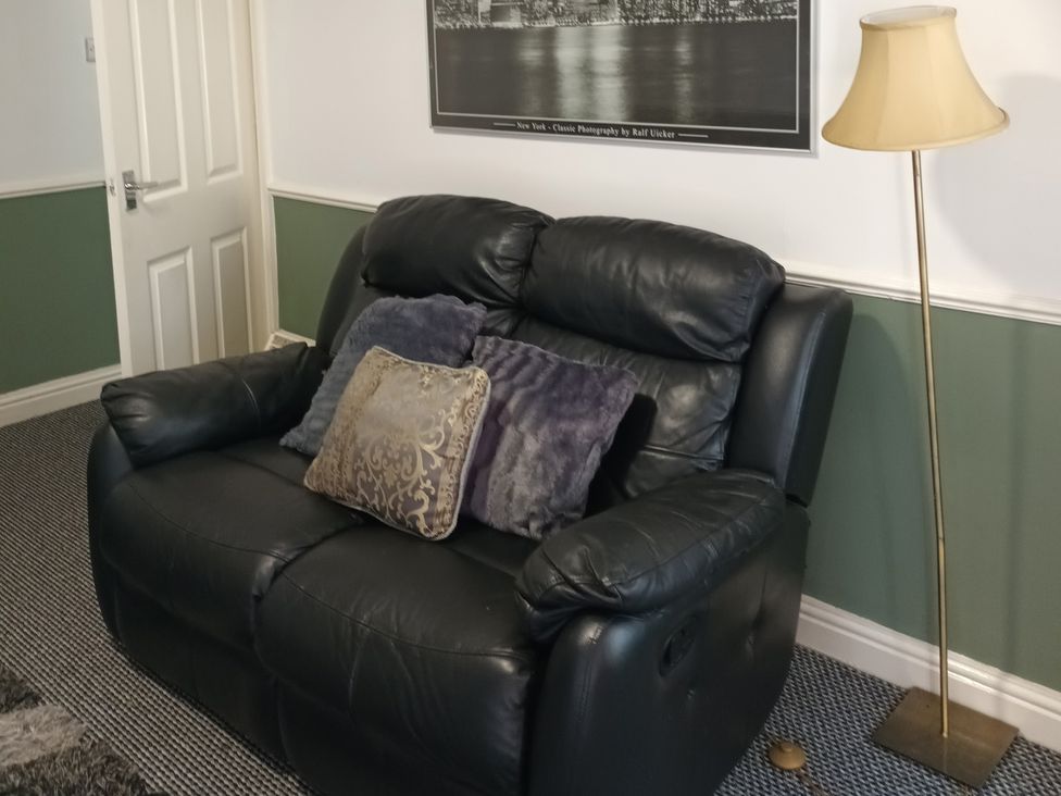 A living room with a sofa and lamp at 11 Kings Court