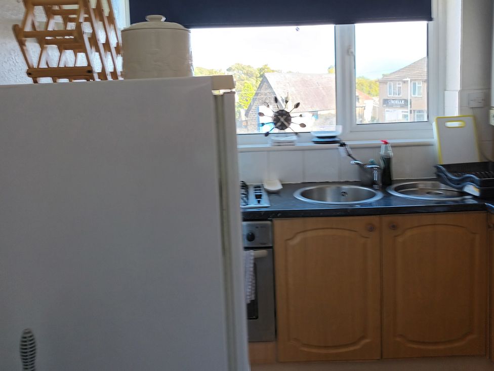 A kitchen with a fridge and sink at 11 Kings Court