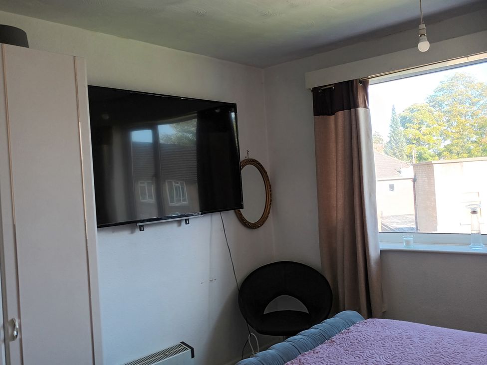 A bedroom with a television on the wall at 11 Kings Court