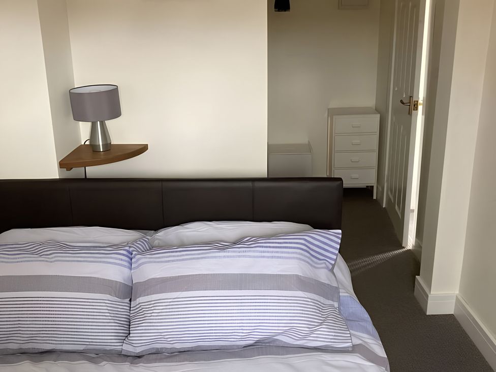 A bedroom with a bed and lamp at The Nook in 