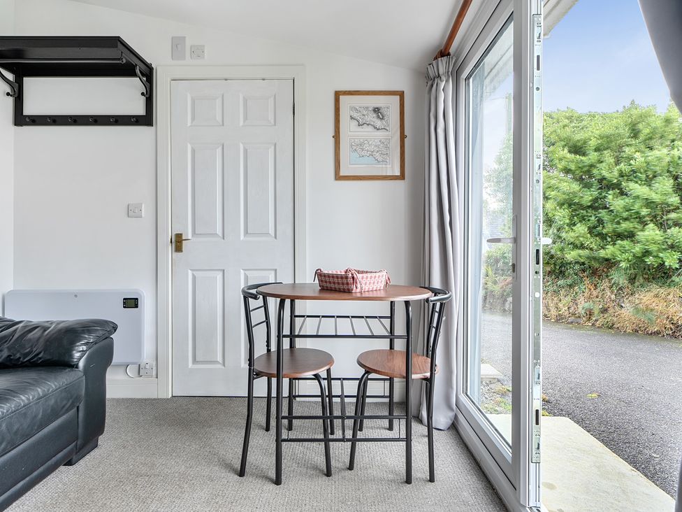 A dining room with a table and chairs at The Nook in Praa Sands
