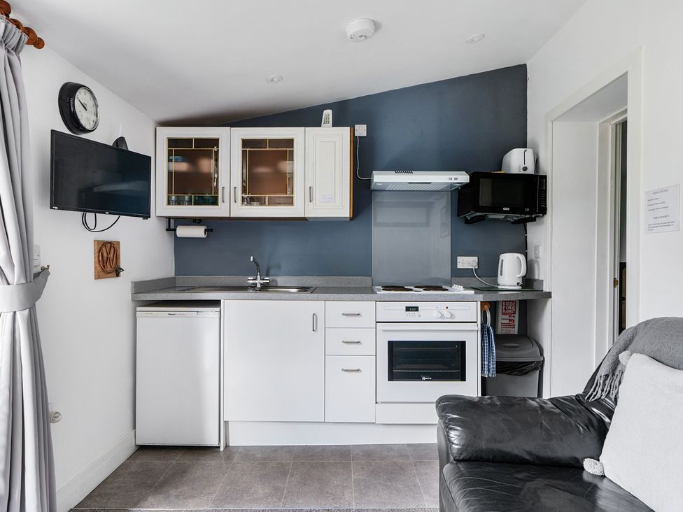 A kitchen with appliances and furniture at The Nook in Praa Sands
