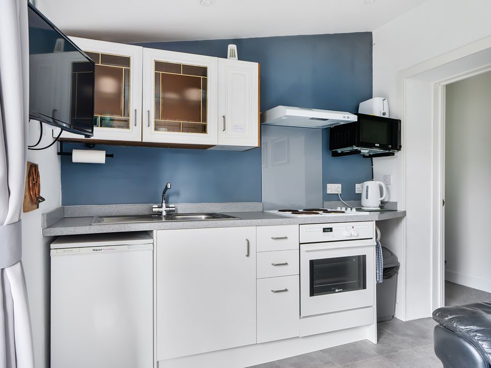 A kitchen with appliances and cabinets at The Nook in Praa Sands