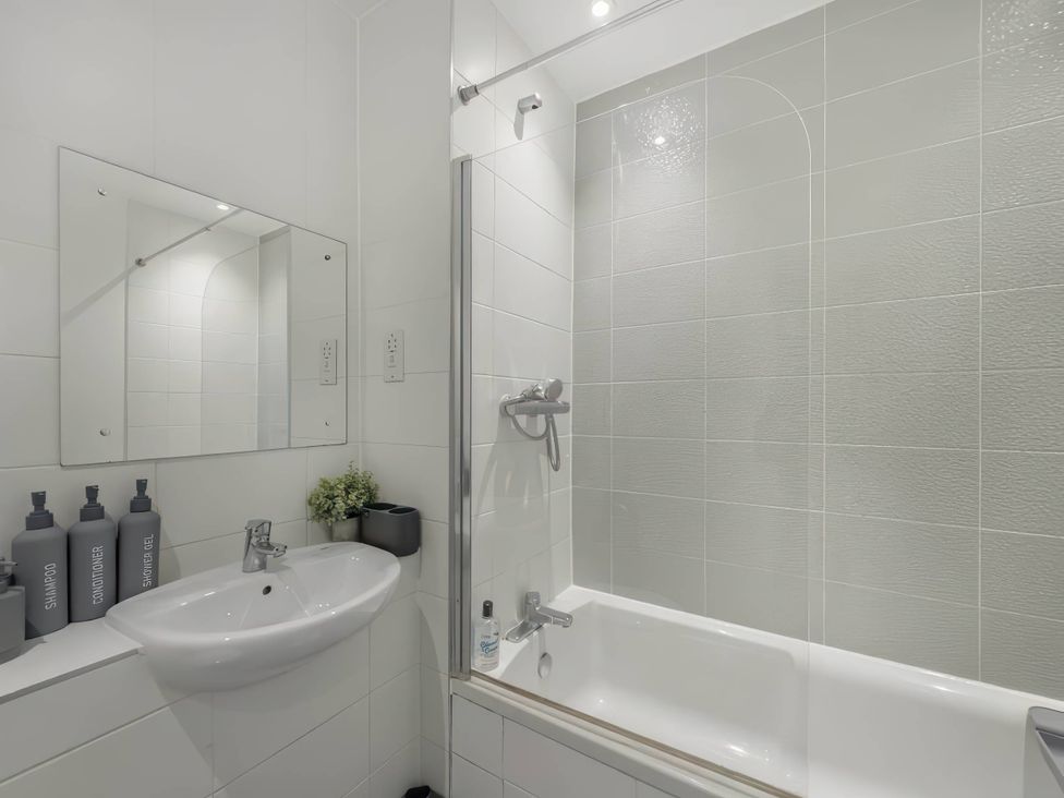 A bathroom with a bathtub and sink at The Old Barn in Manchester