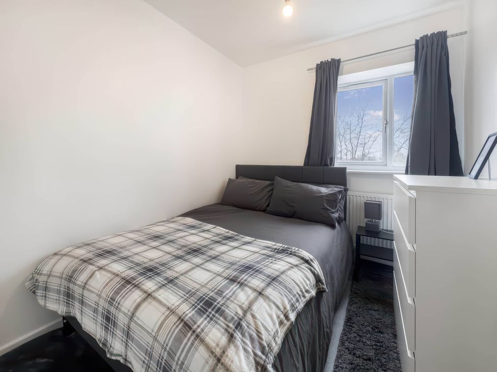 A bedroom with a bed and dresser at The Old Barn in Manchester