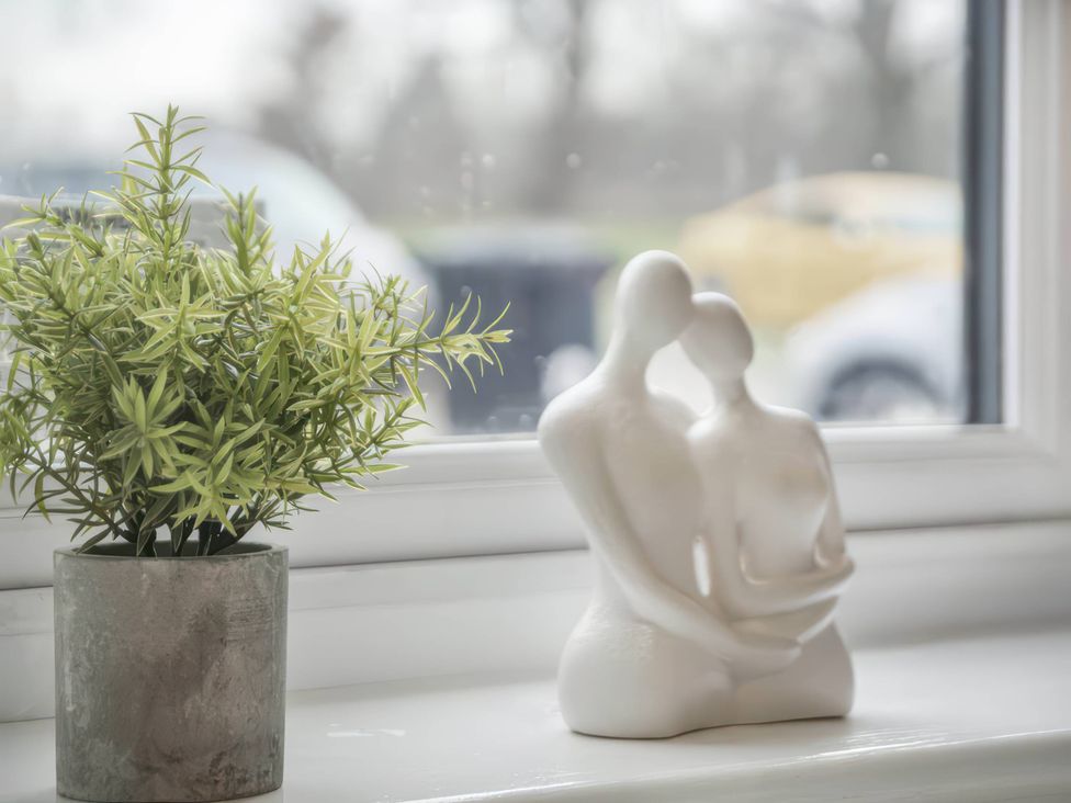 A plant and a sculpture on a windowsill
