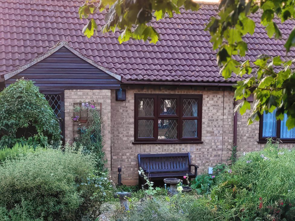 An outdoor area with a house and a bench at a residential property