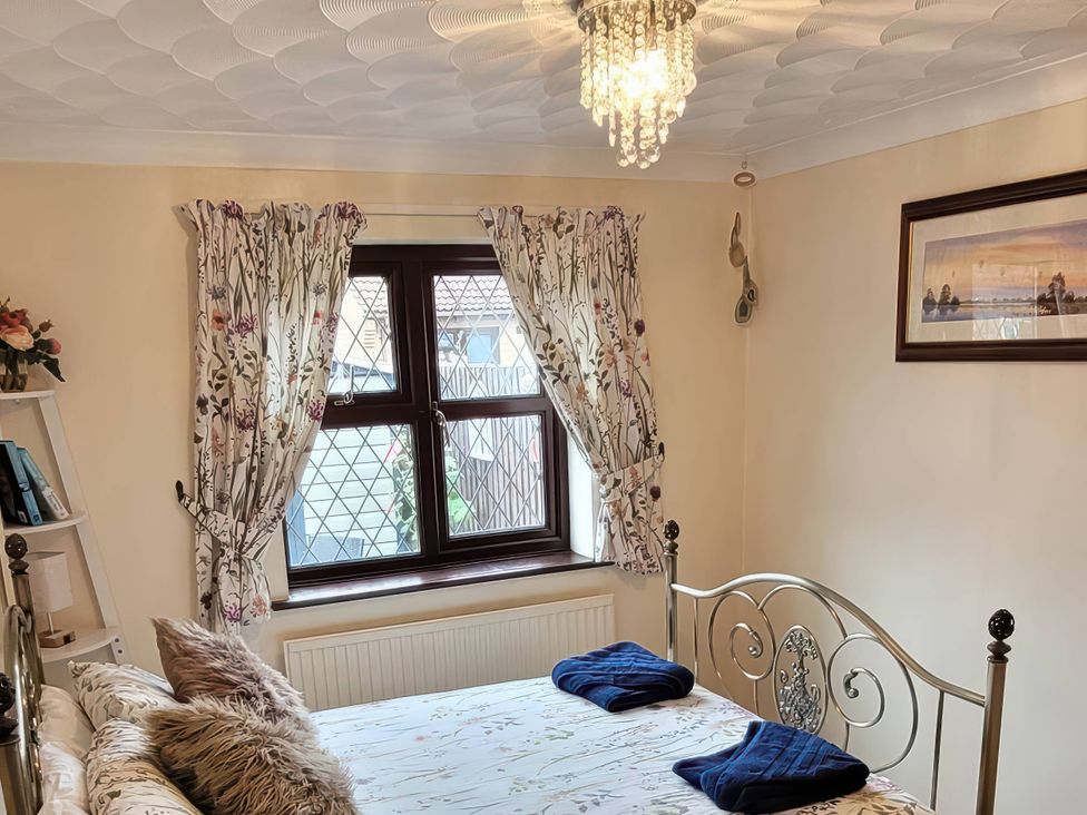 A bedroom with a bed, curtains, and a window at The Old Barn in Manchester