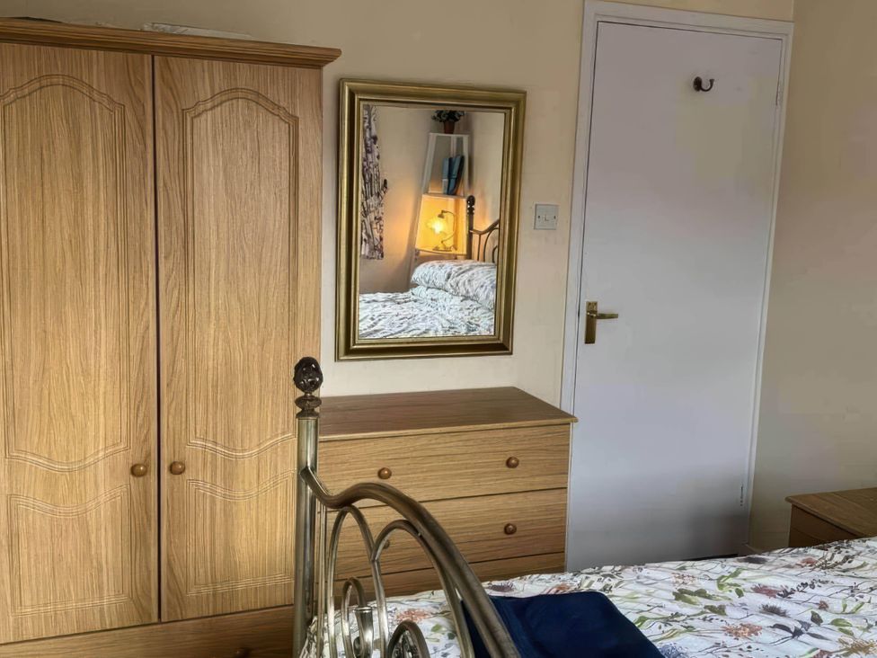 A bedroom with a bed and wardrobe at The Old Barn in Manchester