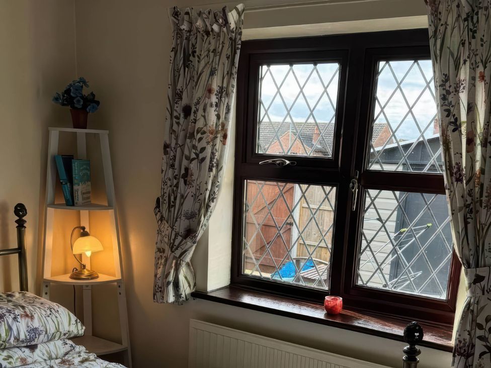 A bedroom with a bed, a window, and a bookshelf at the property in location