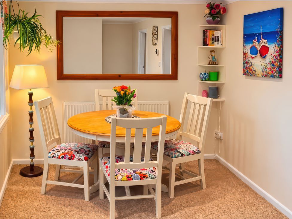 A dining area with a table and chairs at Quackers Heacham