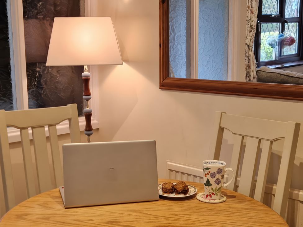 A dining room with a laptop and a cup at Quackers in Heacham