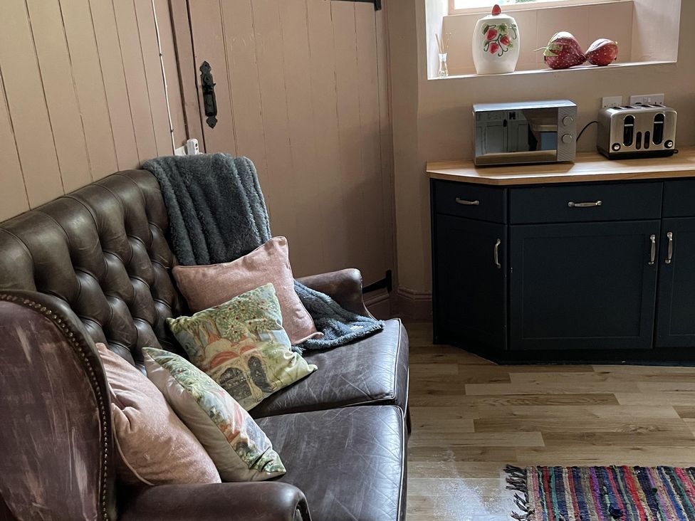 A kitchen with a sofa and countertop appliances at High Dyke Cottage