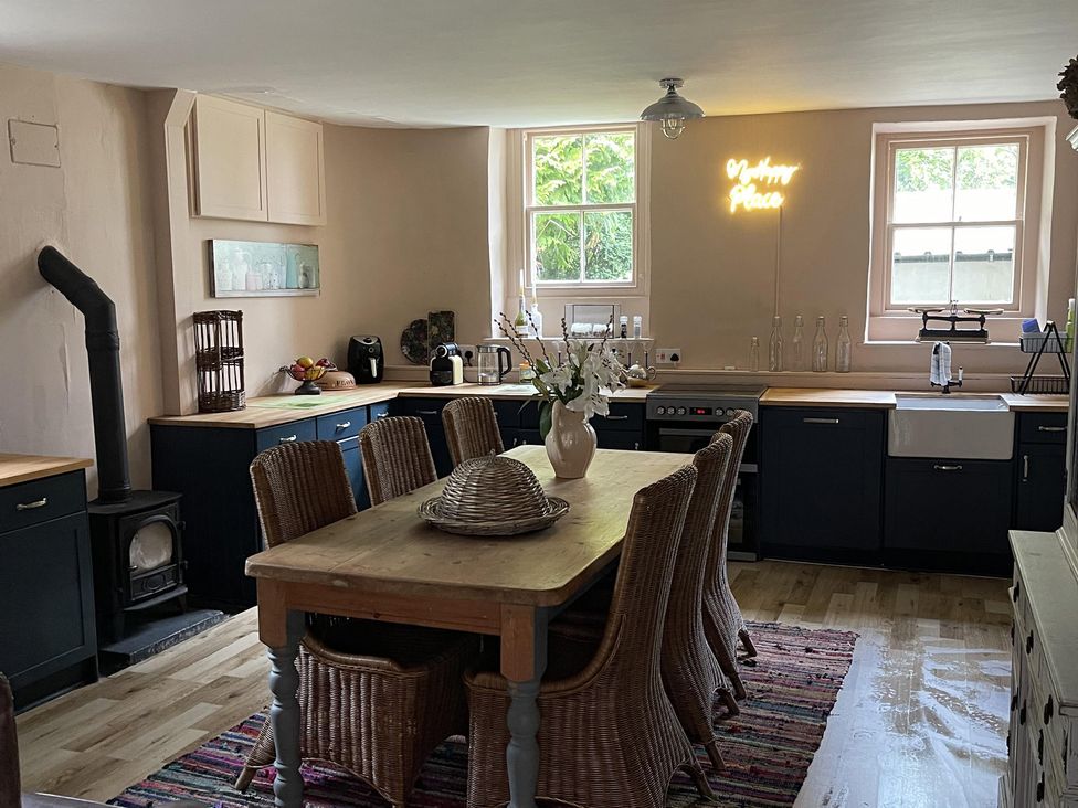 A kitchen featuring a dining table with chairs and a stove at High Dyke Cottage