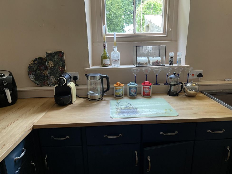 A kitchen countertop with a coffee machine and glassware at High Dyke Cottage