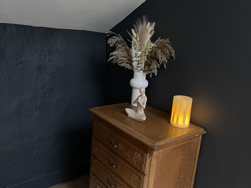 A cabinet with a vase and dried flowers at High Dyke Cottage in 