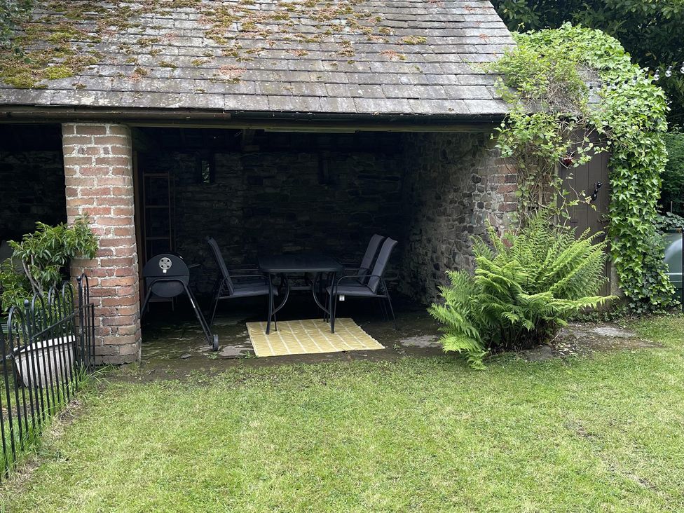 An outdoor seating area with a table and chairs at High Dyke Cottage 