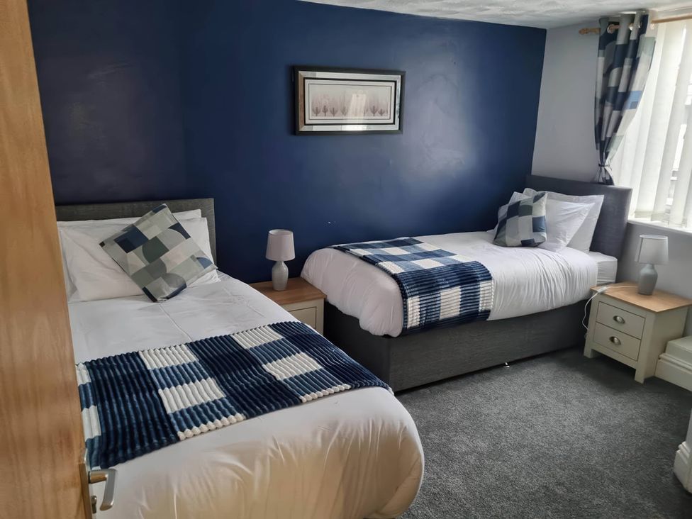 A bedroom with two beds and a nightstand at The Old Barn in Manchester