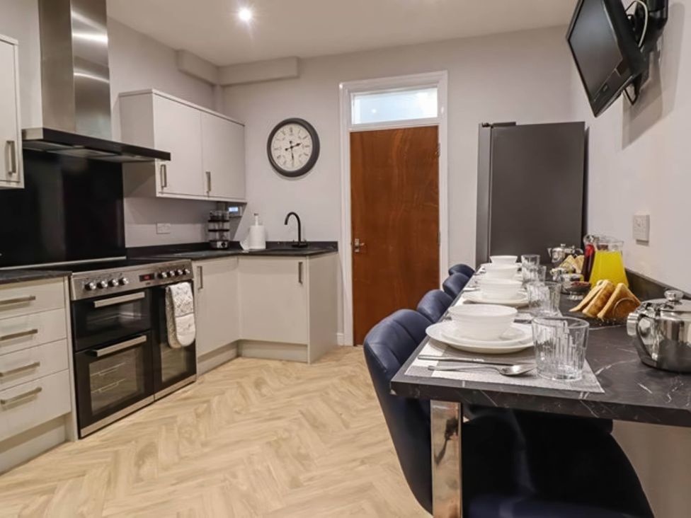 A kitchen featuring an oven, sink, and dining area with table at a property