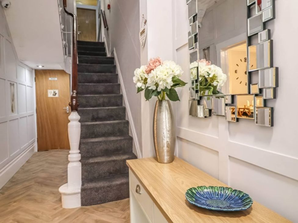 A hallway with stairs and a console table at The Old Barn in Manchester