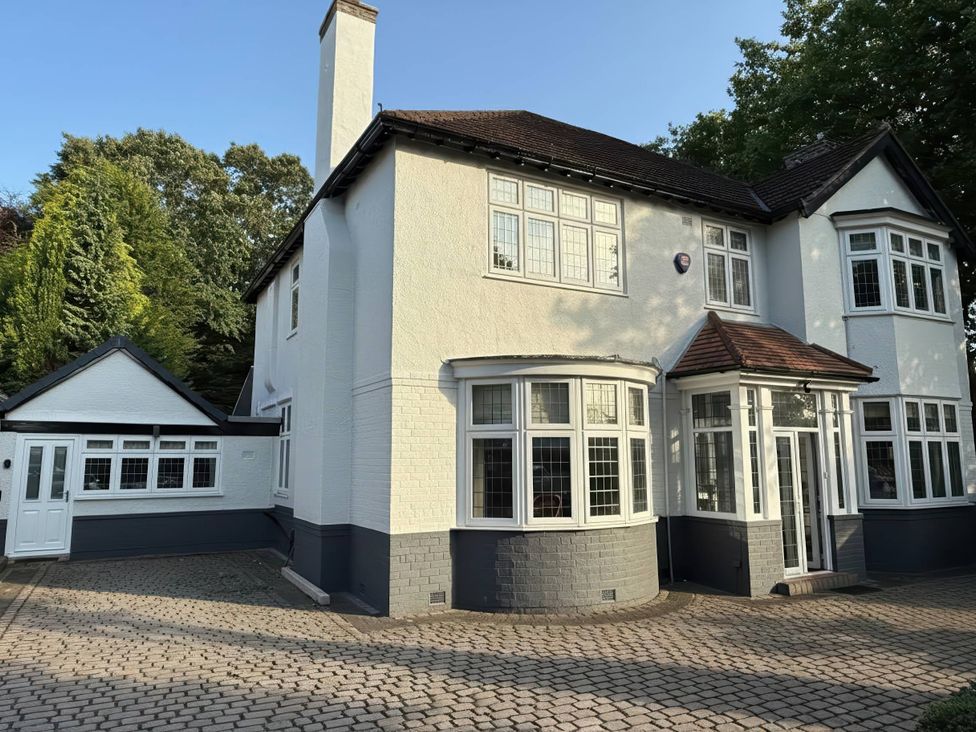 A house with a driveway and trees at a residential property