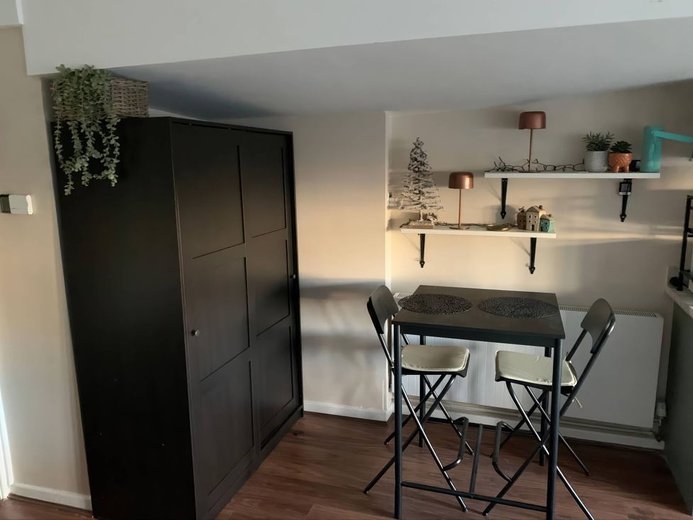 A kitchen with a cabinet, table, and shelves at The Old Barn in Manchester