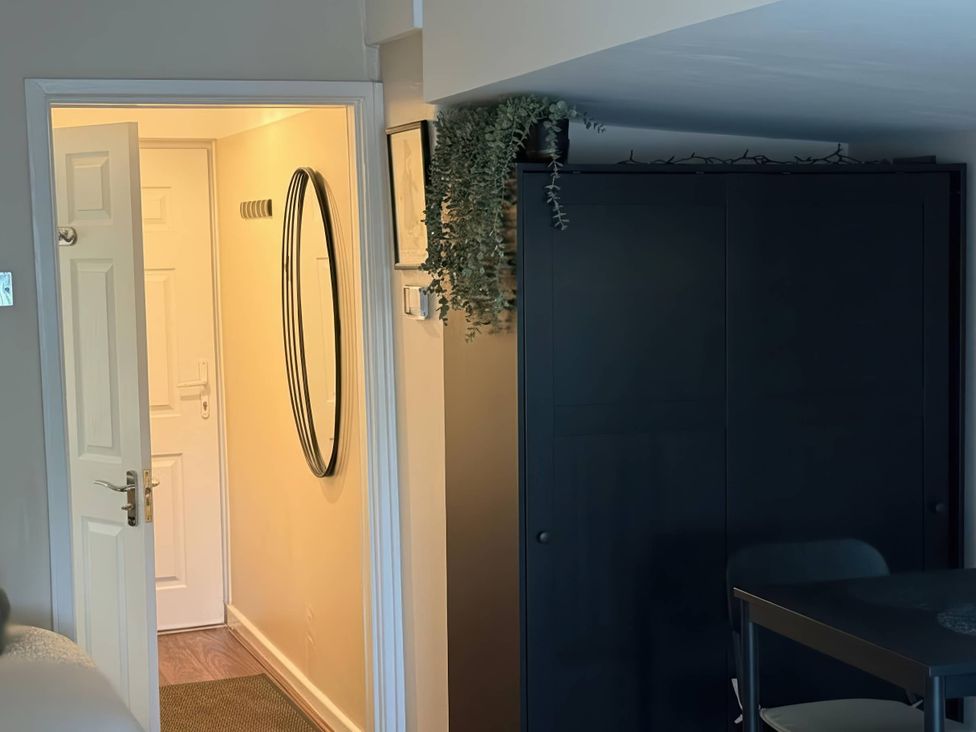 An entrance hall with a mirror and cabinet at the property in unspecified location