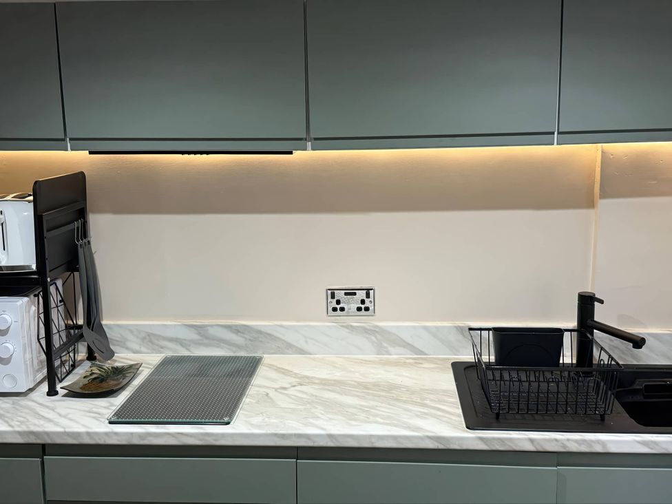 A kitchen countertop with a sink and microwave at the property
