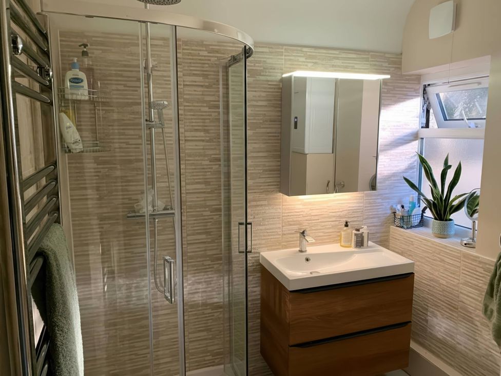 A bathroom with shower, sink, and mirror at The Old Barn in Manchester
