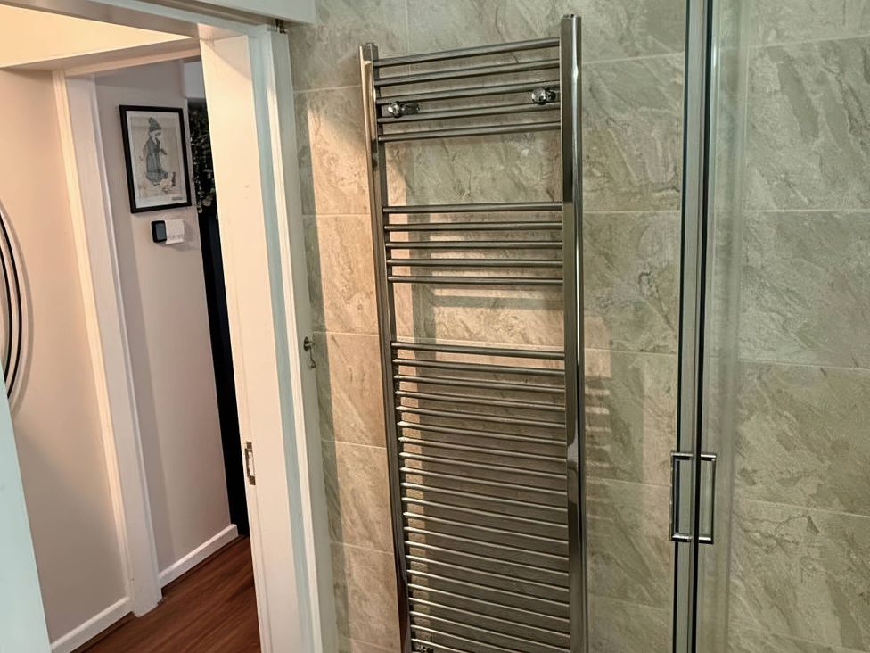 A bathroom with a towel radiator and shower at The Old Barn in Manchester