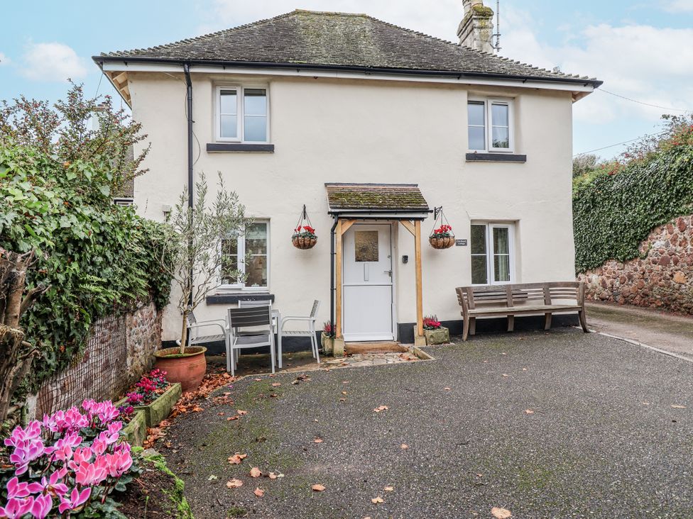 A house with a bench and table at Orchard Cottage in Dawlish