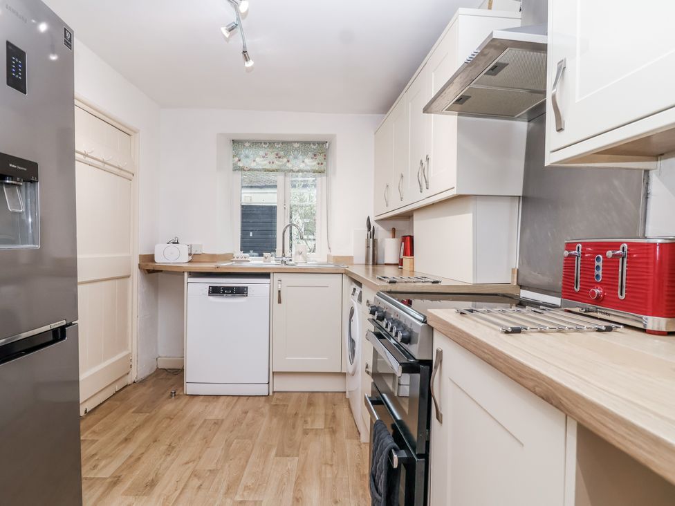 A kitchen with appliances and countertop at Orchard Cottage in Dawlish