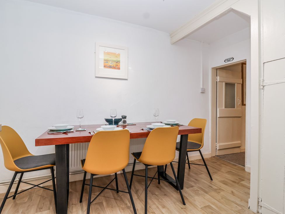 A dining room with a table and chairs at Orchard Cottage in Dawlish