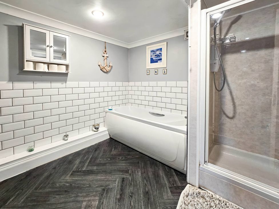 A bathroom with a bathtub and shower at The Old Barn in Manchester