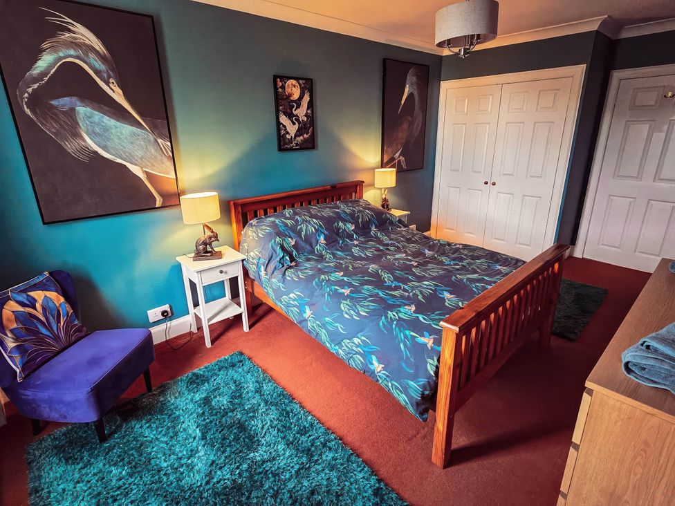 A bedroom with bed and paintings at The Old Barn in Manchester