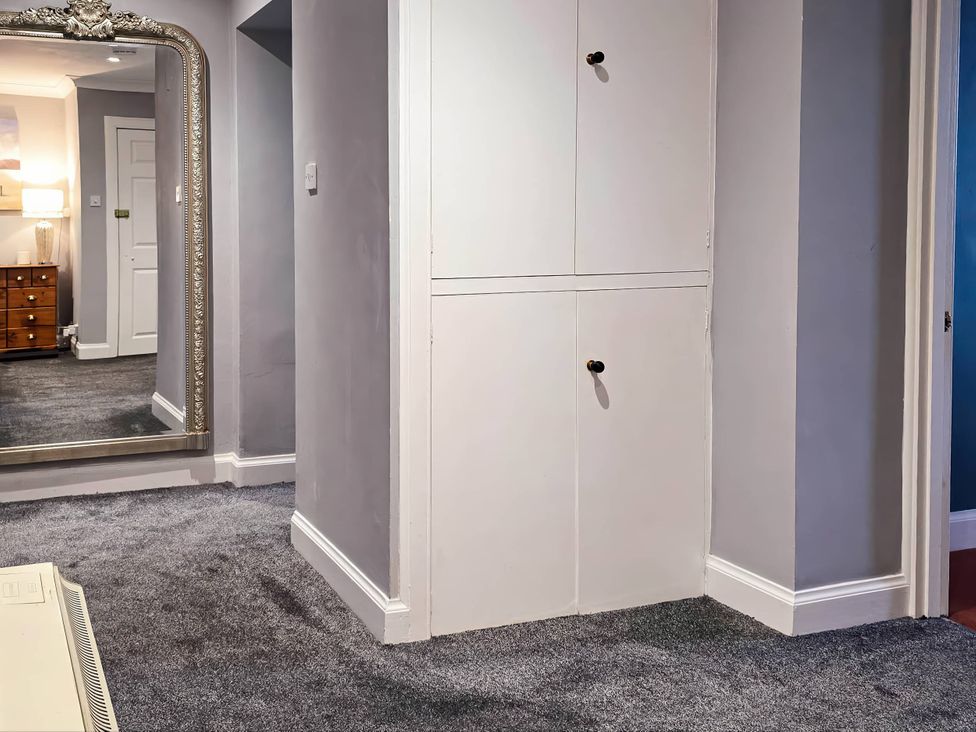 A hallway with a mirror and closet at the property in unspecified location