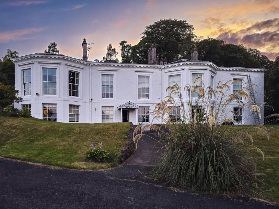 A house with large windows and door in the garden at 