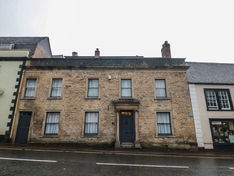 A brick building with windows and a door on a street at ASH HOUSE