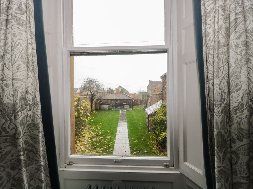 A view from a window showing a garden and buildings at ASH HOUSE