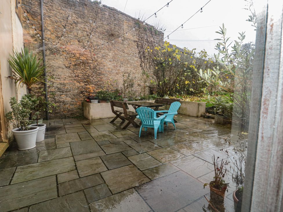 A garden with a stone wall and outdoor furniture at ASH HOUSE