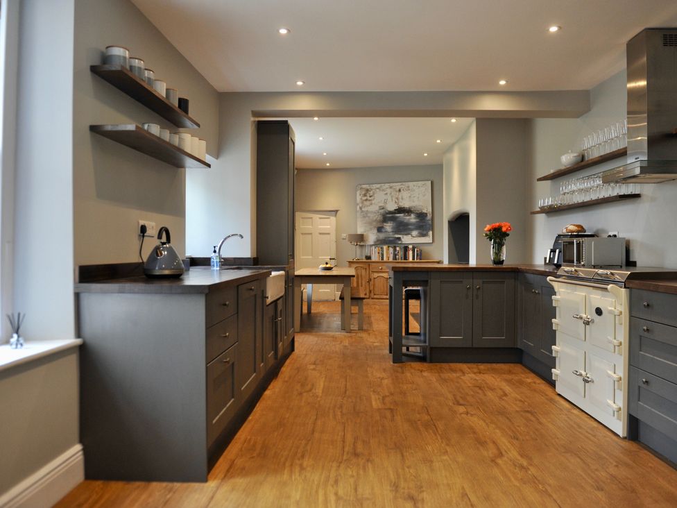 A kitchen with shelves and a table at ASH HOUSE in Wincanton