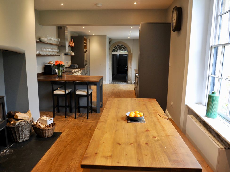 A kitchen with a wooden table and stools at ASH HOUSE Wincanton