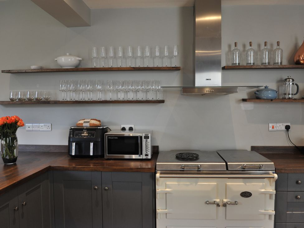 A kitchen with shelves and appliances at ASH HOUSE in Wincanton