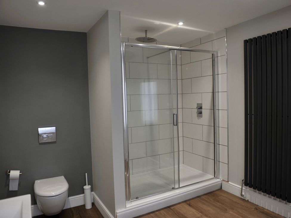 A bathroom with a shower, toilet, and towel rail at ASH HOUSE Wincanton