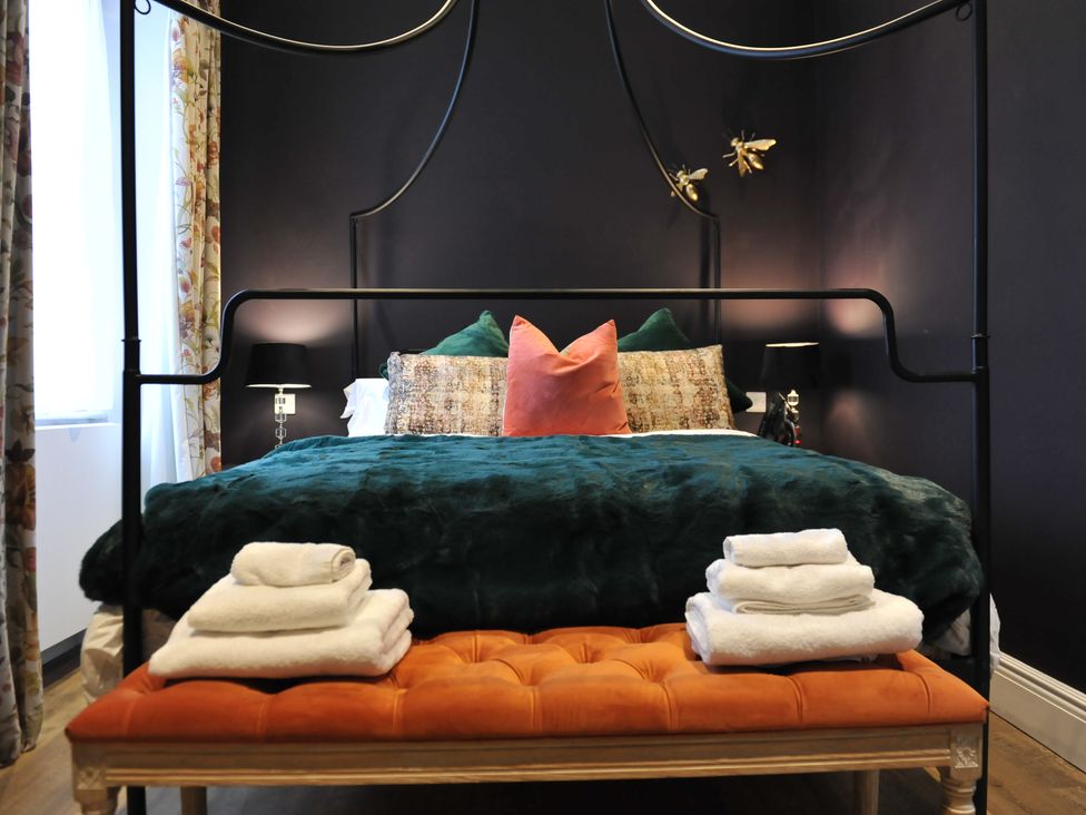 A bedroom with a bed, bench and towels at ASH HOUSE in Wincanton