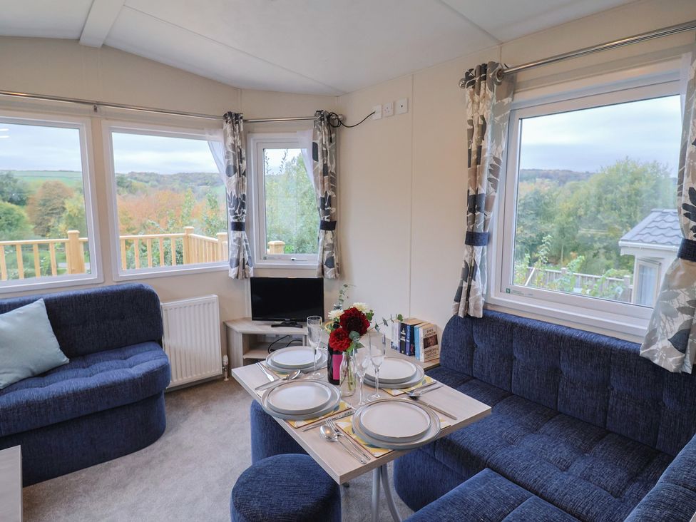 A living room with a dining table and sofa at caravan NEW Uplyme